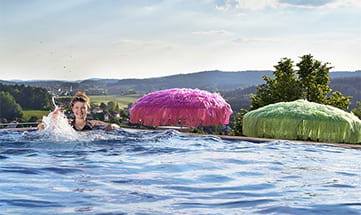 Frau schwimmt im Dachpool