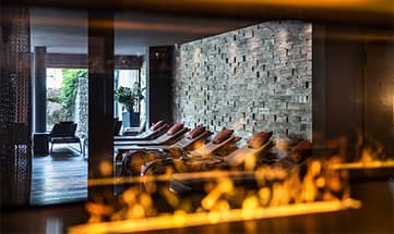 Blick auf die Liegen in der Ruhezone neben Kaminfeuer