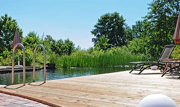 Blick auf den Naturbadesee und Holzterrasse