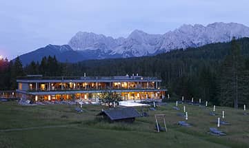 Blick auf das beleuchtete Badehaus und beheizten Aussenpool