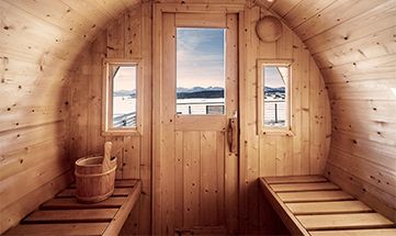 Runde Holzsauna mit Blick auf die Berge