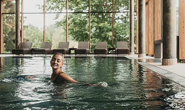 Frau schwimmt im Indoor Pool