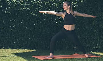 Frau macht Yoga im Garten