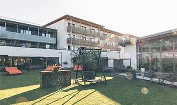 Garten und Außenansicht vom Hotel an einem sonnigen Tag