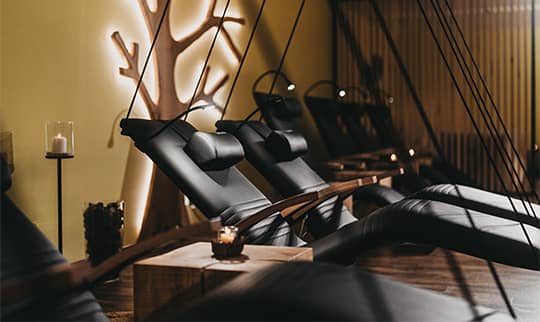 Gemütlich beleuchteter Ruheraum mit zahlreichen Betten und Liegen und bunten Kissen