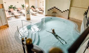 Frau schwimmt im Indoor Pool