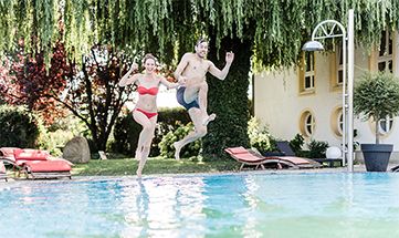 Paar springt in den Pool