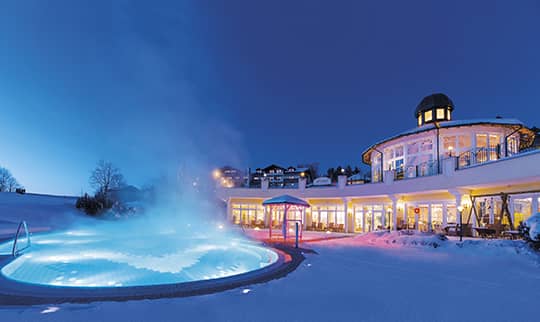 Dampfender Außenpool am Abend im Winter