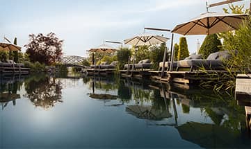 Naturbadesse mit Liegen und Sonnenschirmen