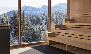 Holzsauna mit Bänken und Glasfassade