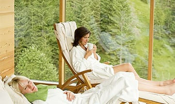 Zwei Frauen in weißen Bademänteln genießen den Ausblick