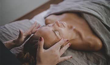 Frau wird im Gesicht massiert