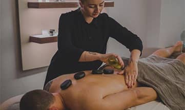 Mann genießt eine Hot Stone Massage