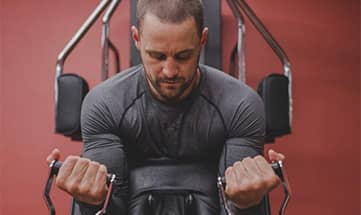 Mann macht Krafttraining an modernen Geräten