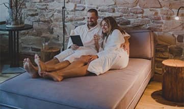 Paar in weißen Bademänteln entspannt gemeinsam