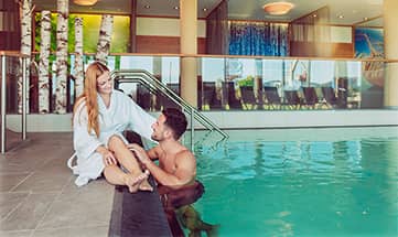 Paar am Beckenrand vom Pool