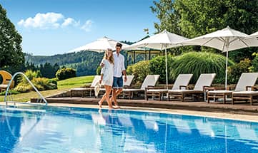 Paar spaziert am Außenpool