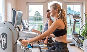 Mann und Frau trainieren im Fitnessraum