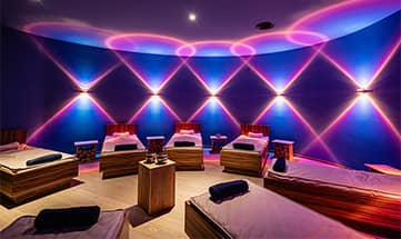 bunt beleuchteter Wellness Ruheraum mit mehreren Liegen