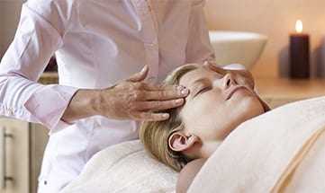 Frau wird am Gesicht massiert