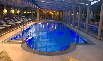 Beleuchteter Außenpool am Abend von vorne