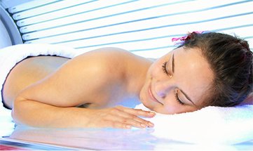 Frau sonnt sich unter Solarium