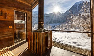 Außensauna mit Blick auf verschneite Berge