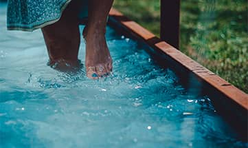 Eine Frau geht durch Wasser im Barfussweg