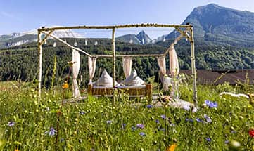 Bett unter freiem Himmel auf einer grünen Wiese