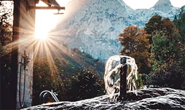 Wasser sprudelt aus einem Brunnen mit Bergen im Hintergrund