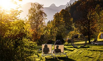 Ein paar entspannt im Garten auf Liegen bei heller Sonne