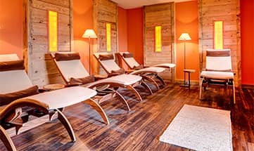 Der Ruheraum Salzkammerl mit mehreren Liegen und rötlicher Beleuchtung