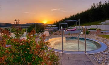 Outdoor Whirlpool im Garten bei Sonnenuntergang