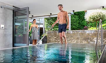 Paar schreitet gemeinsam ins Wasser