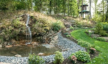 Kleiner Wasserfall im Wellnessgarten im Sommer