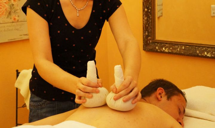Mann erhält eine Kräuterstempelmassage