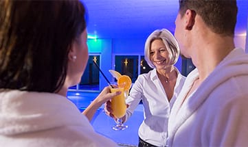 Paar bekommt Cocktail serviert am Pool