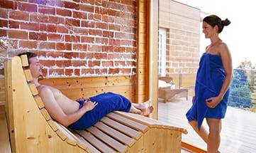 Paar in blauen Handtüchern in der Sauna